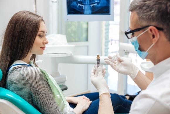 Dentist and patient discussing the four step dental implant process