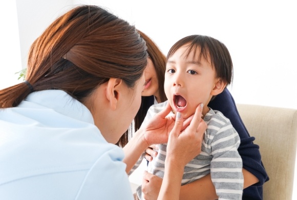 Dentist examining child during first dental visit