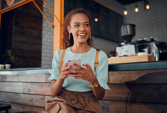 Smiling woman sitting on barstool at restaurant