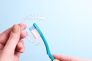 Patient cleaning clear aligner with toothbrush