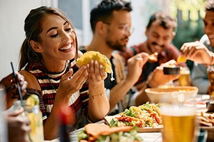 Woman smiling while eating lunch with friends at restaurant