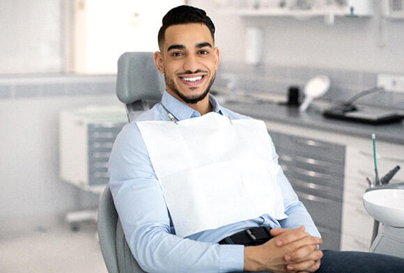 man smiling while sitting in treatment chair