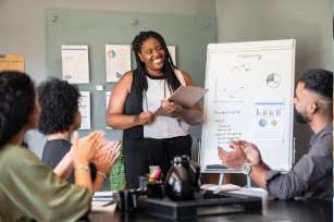 Woman smiling while giving presentation at work