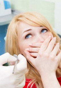 a woman covering her face and peeking through her fingers