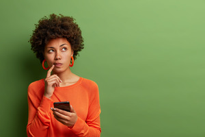 Woman holding phone and wondering