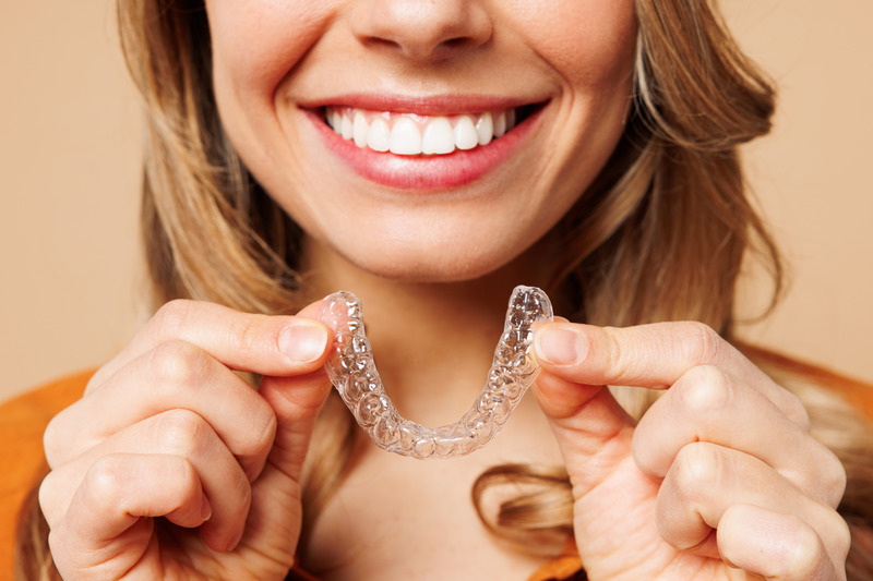 Patient smiling with their Invisalign aligners